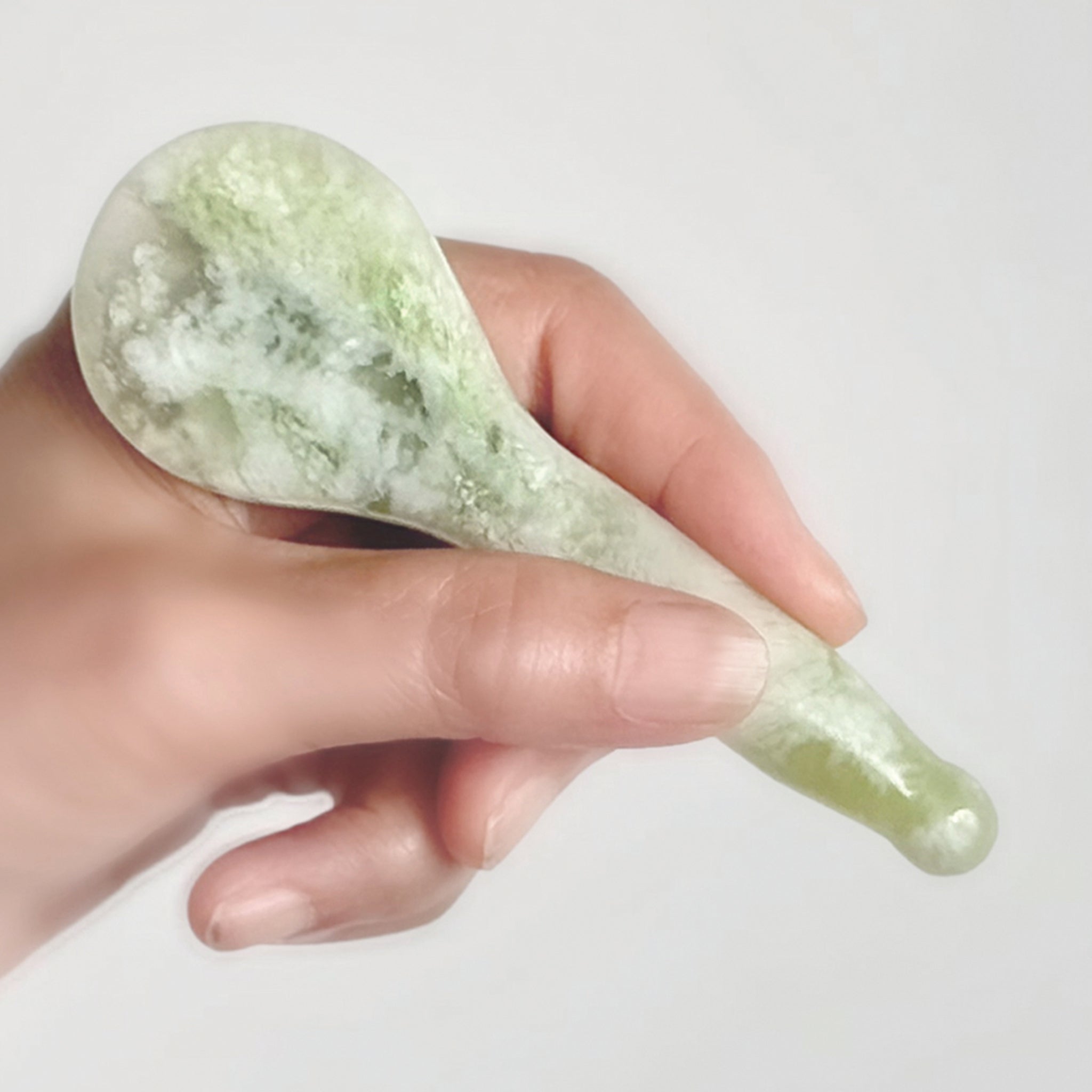 Jade Gua Sha tool in hand