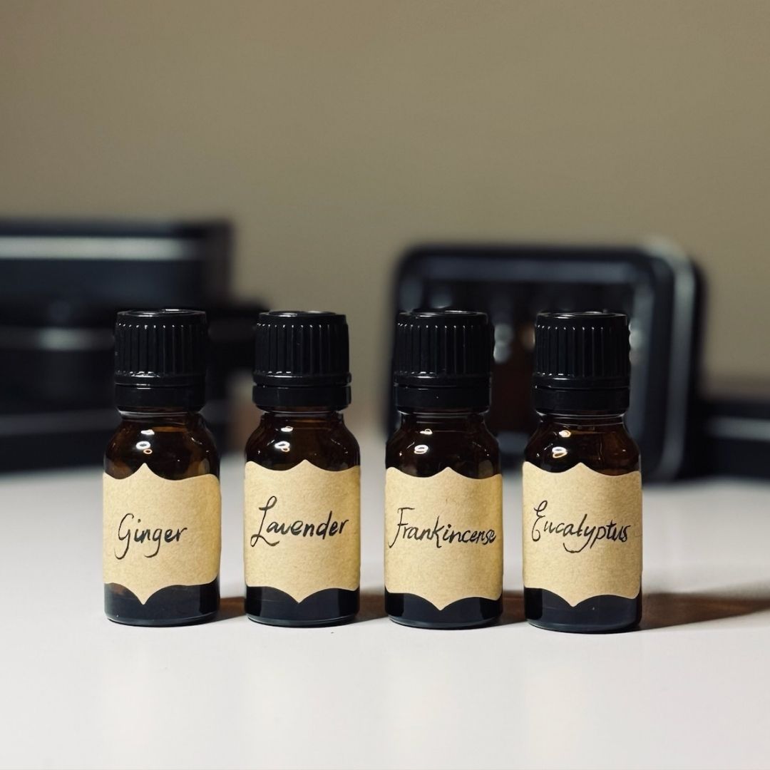 Essential oils bottles labeled Ginger, Lavender, Frankincense, Eucalyptus for skin care
