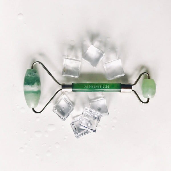 Jade roller surrounded by ice cubes