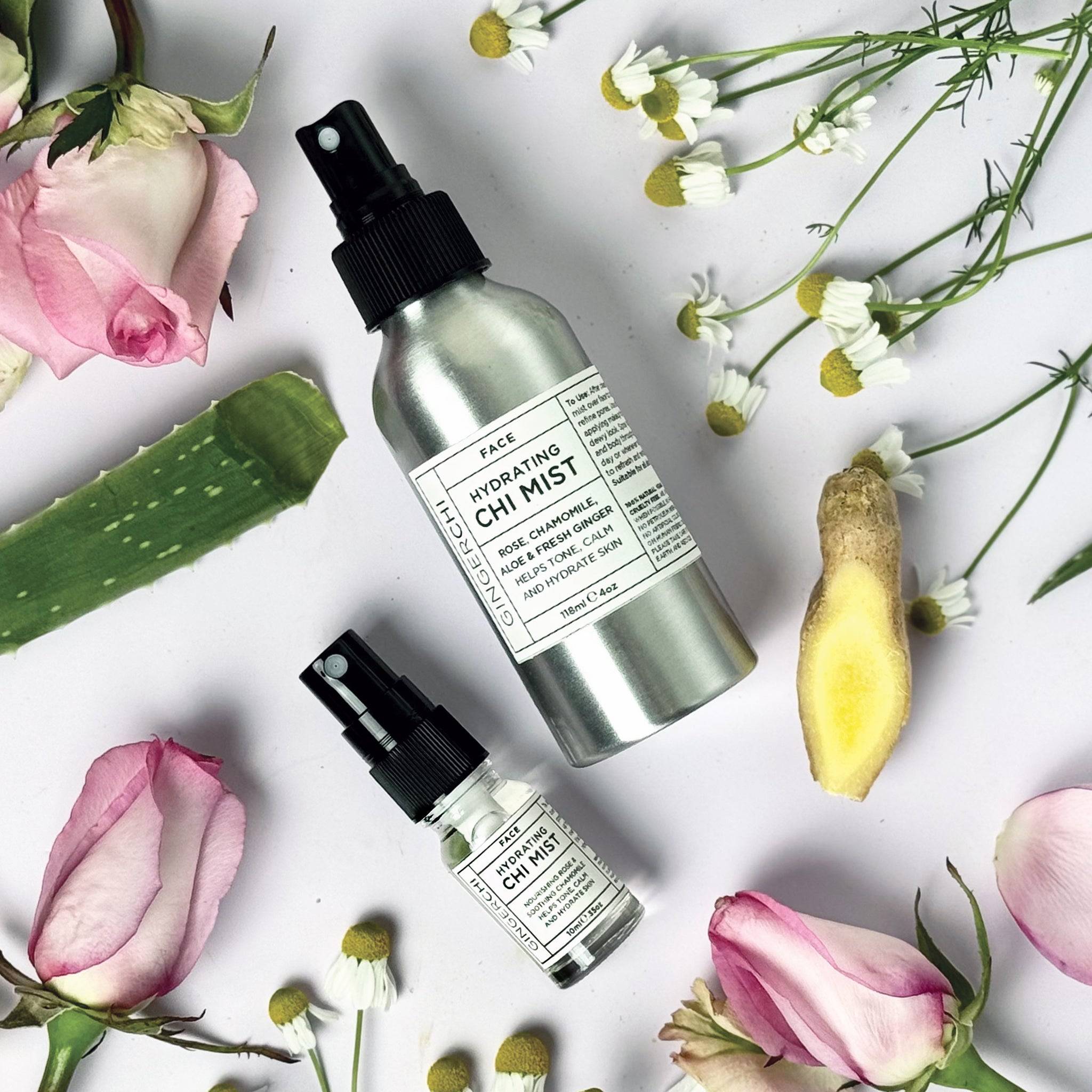 Travel size facial mist with rose, chamomile, aloe, and ginger surrounded by flowers and aloe vera