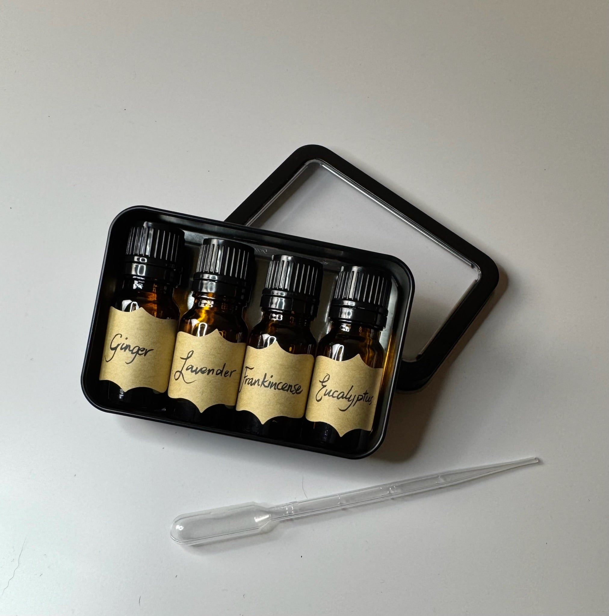 Essential oil bottles with handwritten labels in a black tray